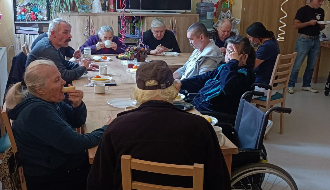 Mieszkańcy DPSu przy stole podczas zabawy Andrzejkowej