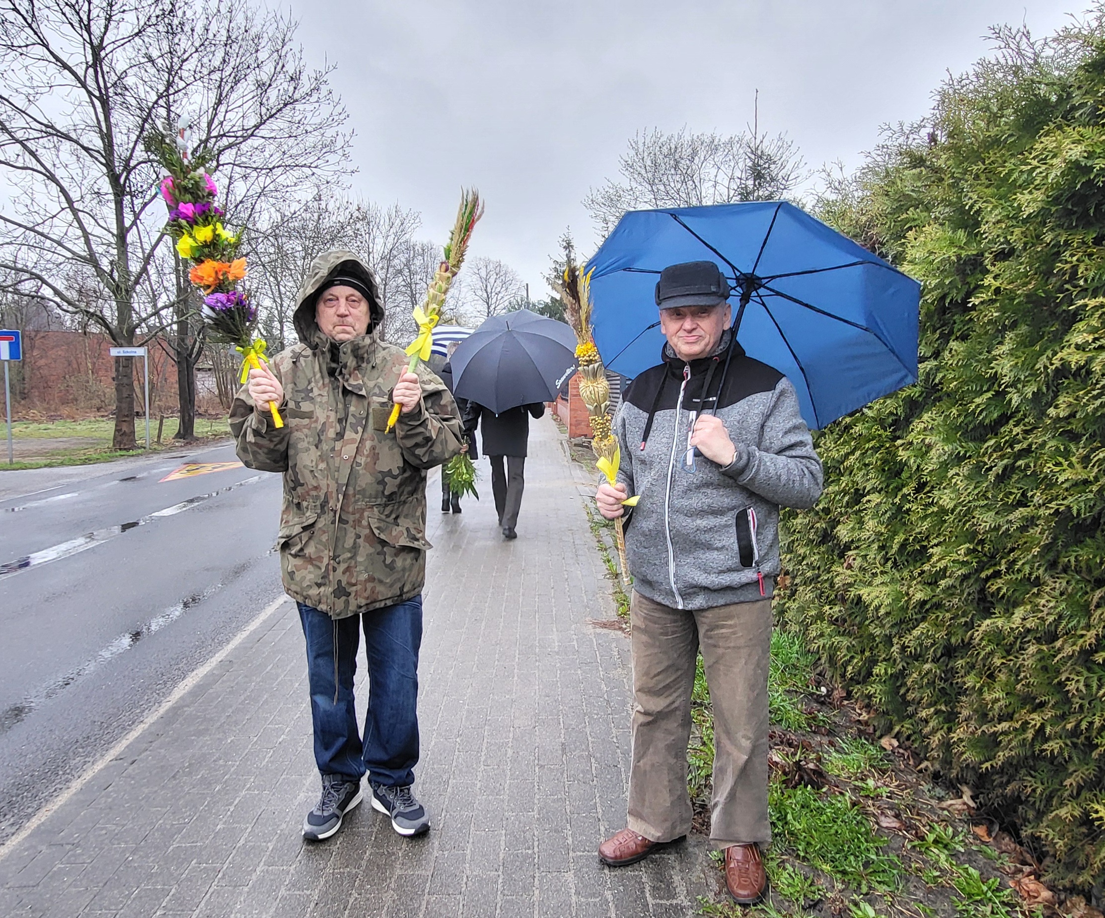 Dwóch mieszkańców DPSu trzymają palmy wielkanocne po święceniu 